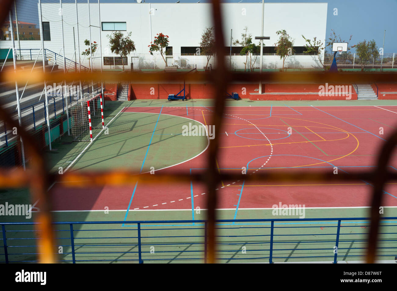 Guardando attraverso una recinzione di una comunità centro sportivo per calcetto, pallacanestro e skateboard. Playa San Juan, Foto Stock