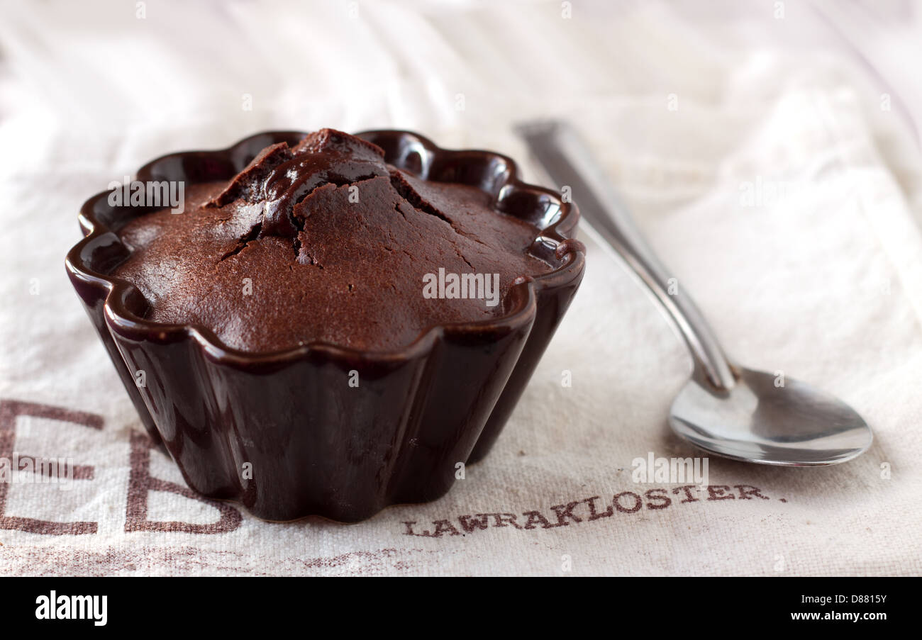 Il francese in casa torta al cioccolato in un marrone frower-stampo sagomato sul lino rurale Foto Stock