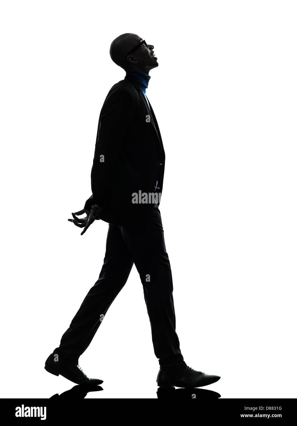 Uno nero africano uomo che cammina cercando sorridente in silhouette studio su sfondo bianco Foto Stock