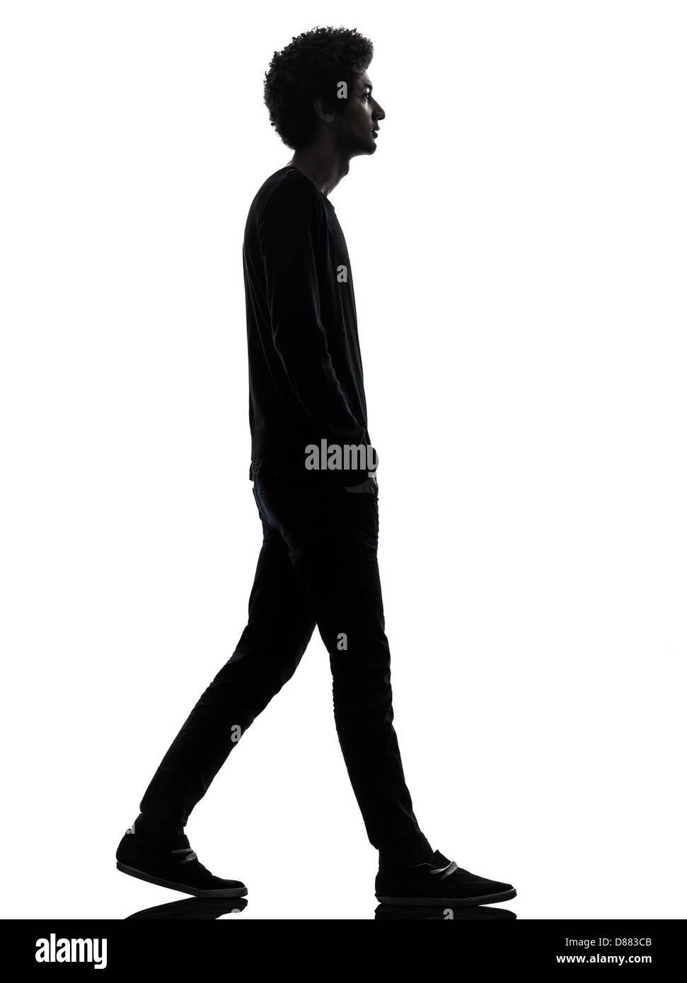 Un africano bel giovane uomo a camminare in silhouette studio isolato su sfondo bianco Foto Stock