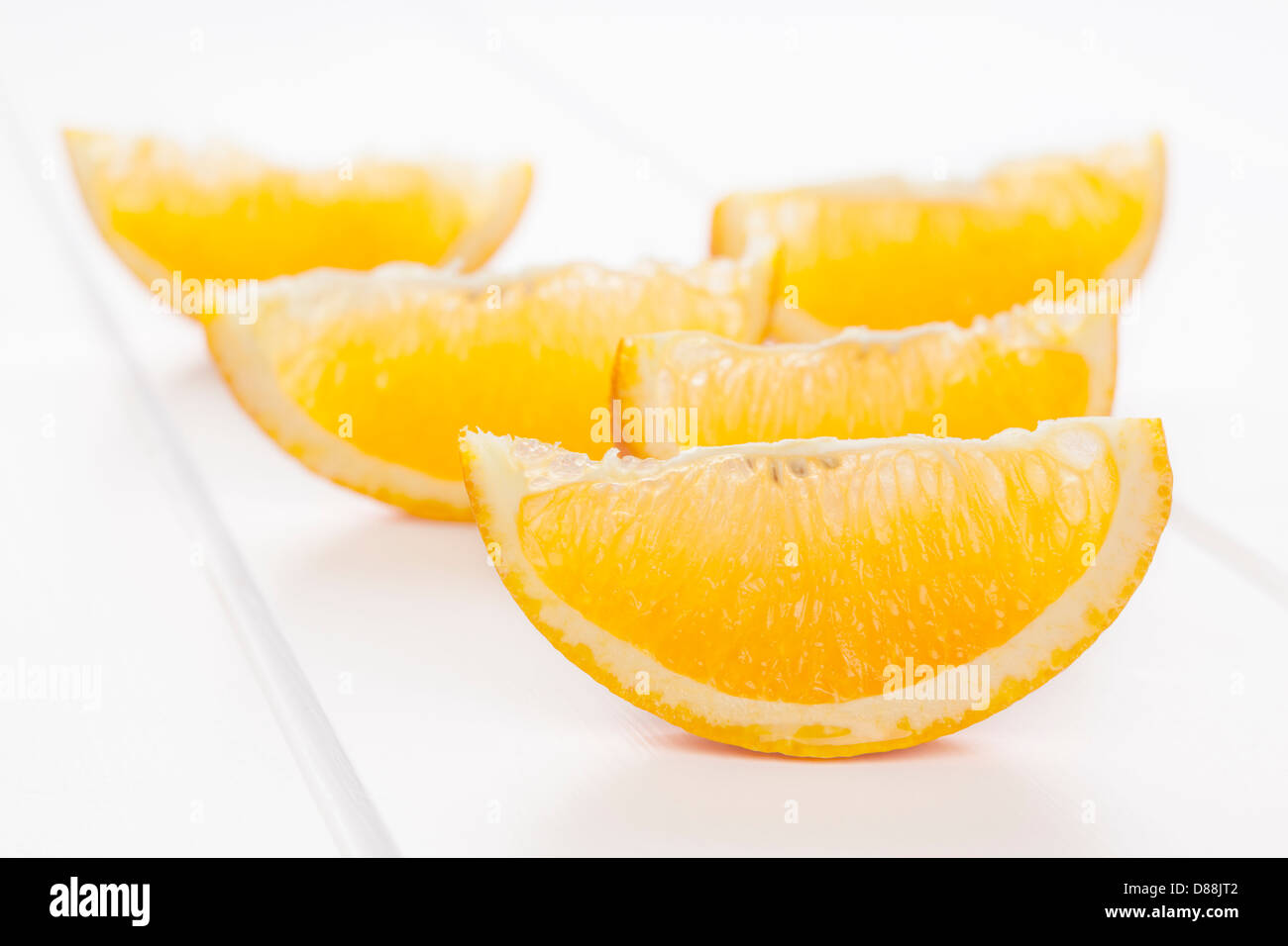 Spicchi d'arancia o le fette su uno sfondo bianco con le ombre morbide. Foto Stock