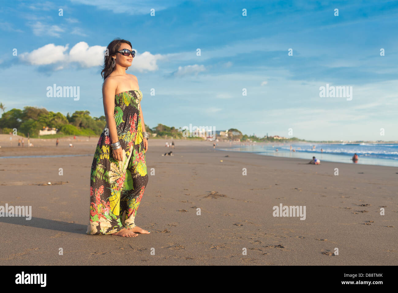 Giovane donna asiatica in abito floreale sulla spiaggia di Bali Foto Stock