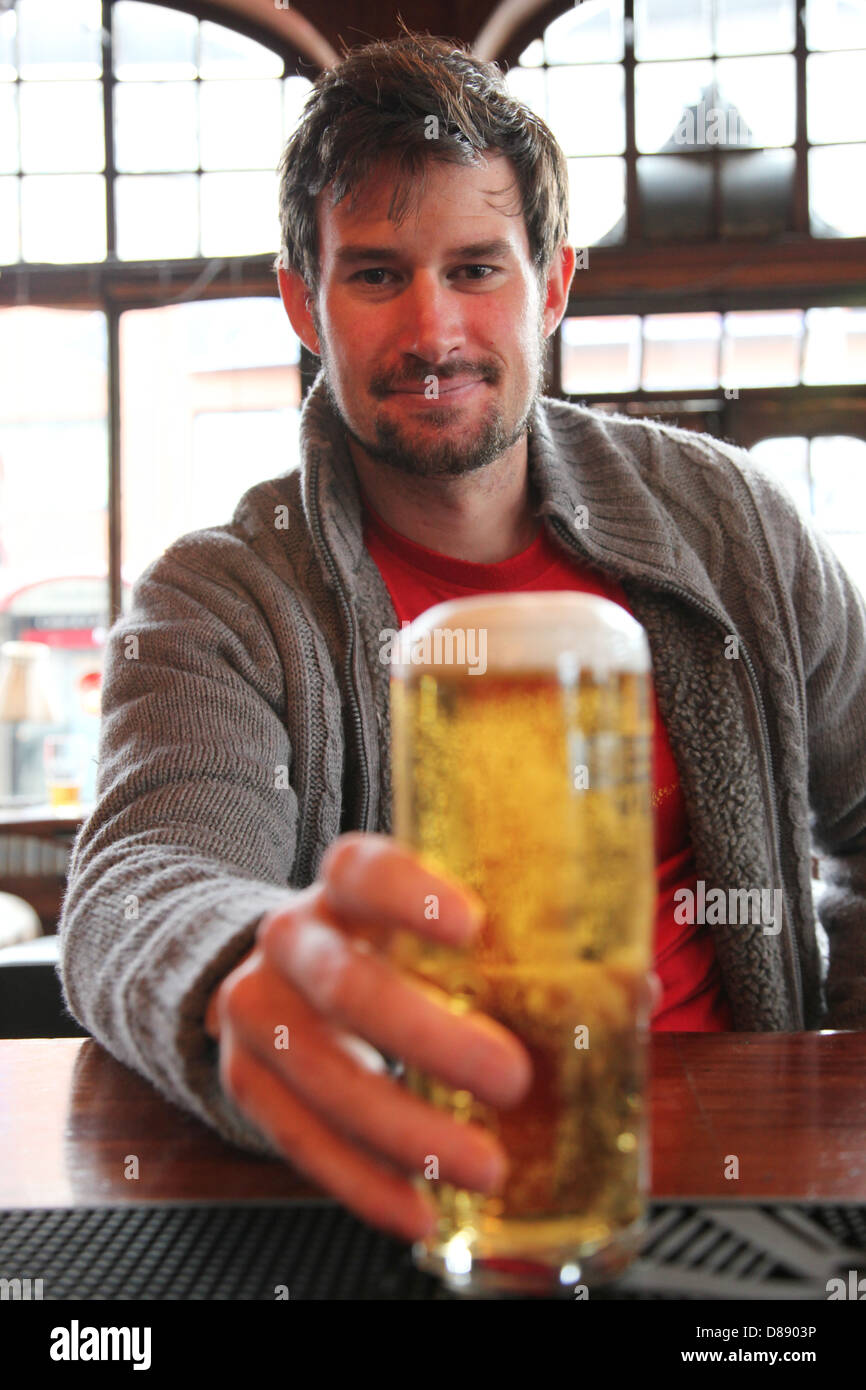 Un uomo si prepara a bere una pinta di birra in un pub Inglese. Il Leone Nero Foto Stock