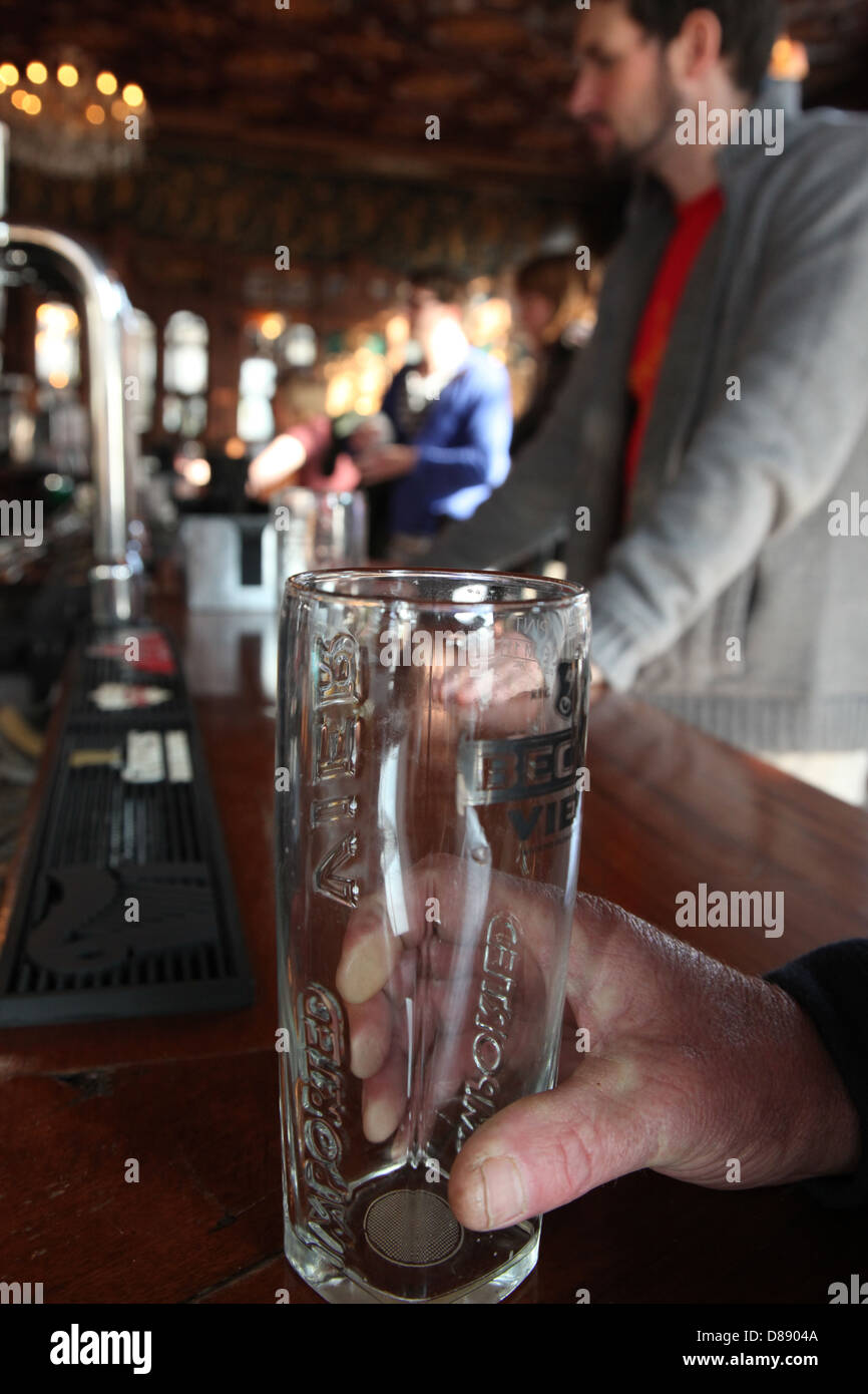 Una pinta di birra vuota su una barra in un tradizionale pub inglese. Foto Stock