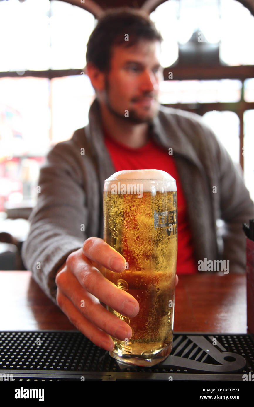 Un uomo si prepara a prendere un sorso al di fuori di un pieno pinta di birra in un pub inglese Foto Stock