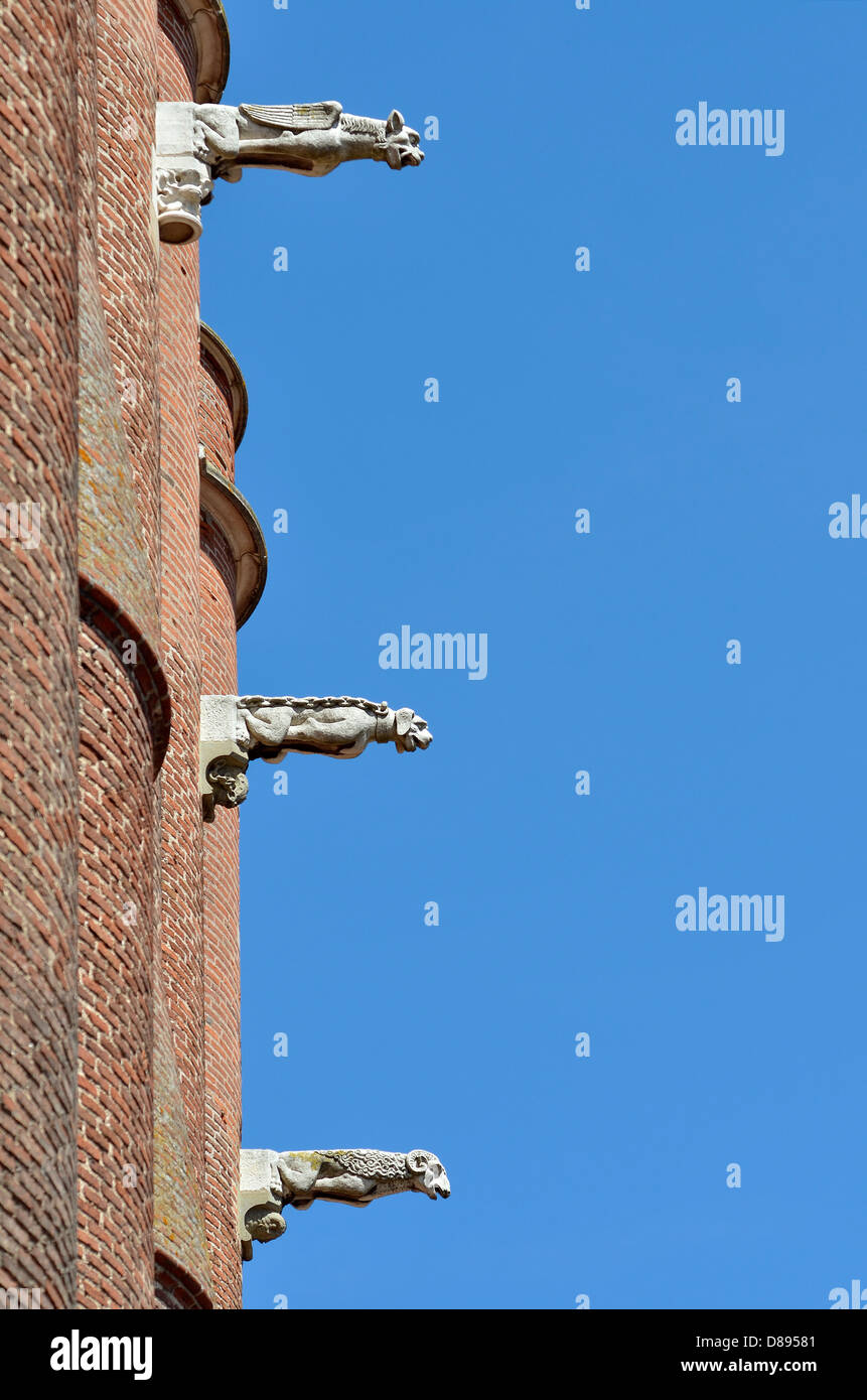 Tre gargoyles sul cielo blu, sfondo della Sainte Cécile cattedrale realizzata in mattoni rossi a Albi nel sud della Francia, Midi P Foto Stock