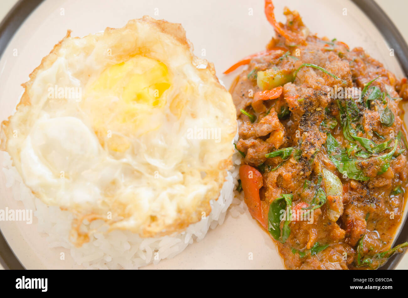 Vista dall'alto di uovo fritto con riso e carne di maiale fritto con peperoncino e salsa al curry Foto Stock