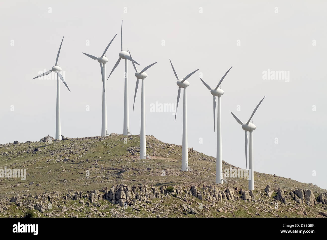Un paio di turbine eoliche sulla cima di un colle arido Foto Stock