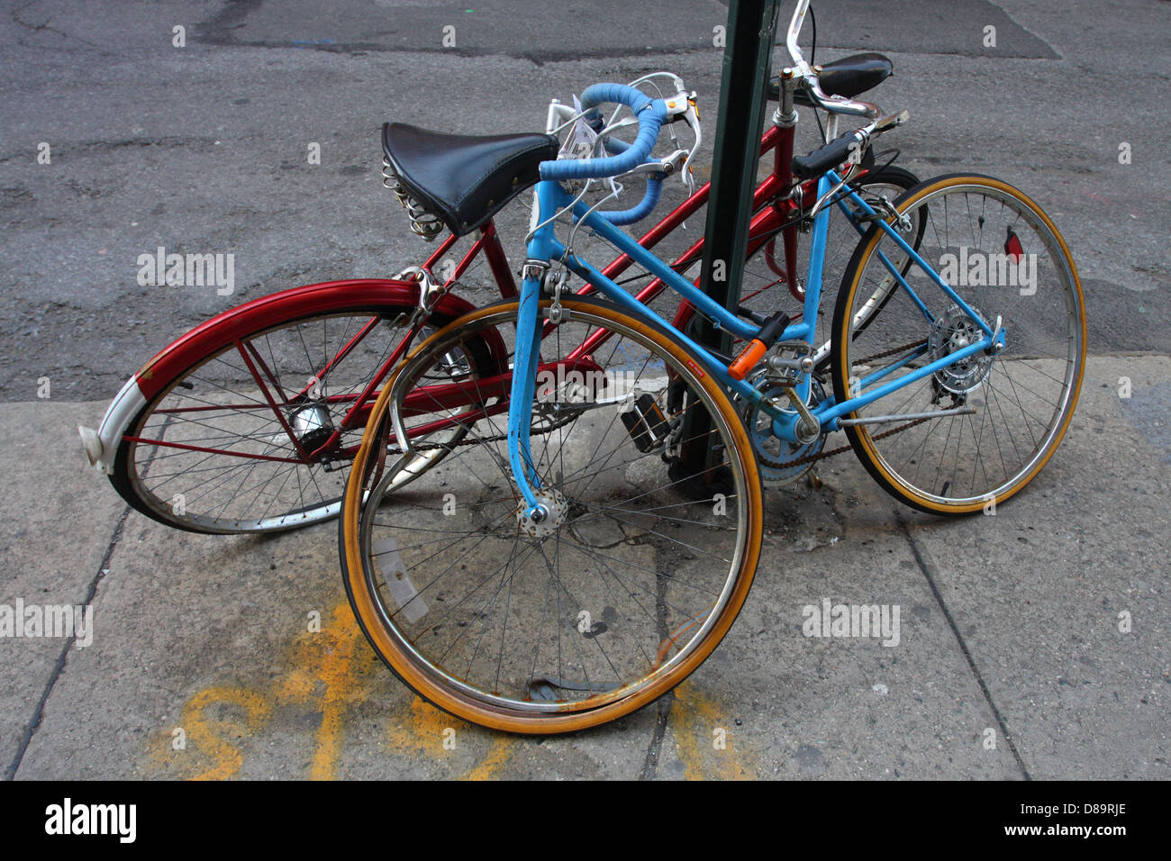 Una coppia di biciclette abbandonate incatenato ad un palo. Foto Stock