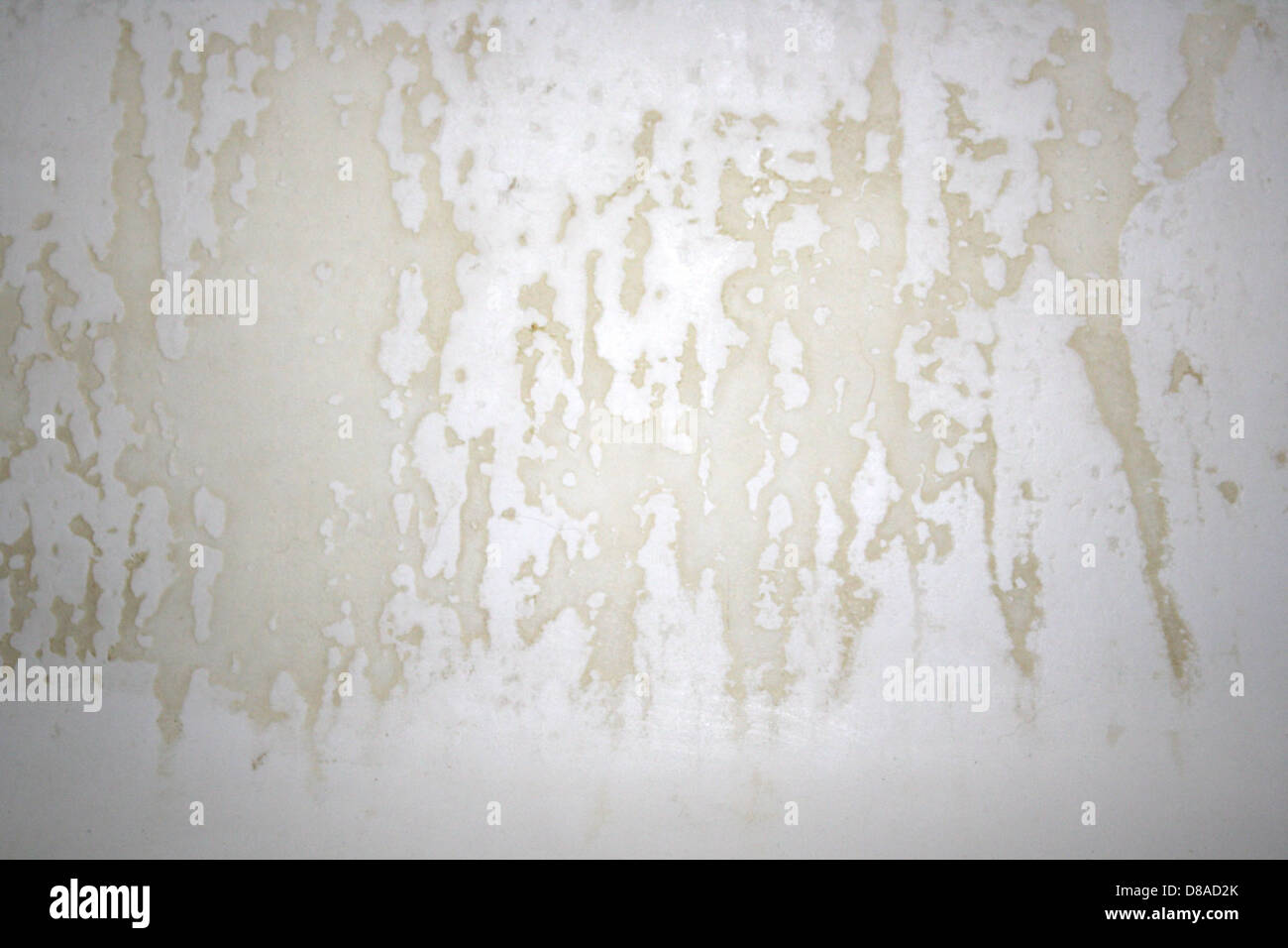 Primo piano di una superficie danneggiata della vasca da bagno in porcellana che mostra segni visibili di usura, graffi e granulosità. La superficie appare invecchiata e intemprata, evidenziando il deterioramento della vasca. Foto Stock
