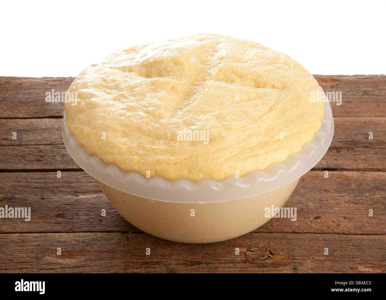 In aumento la pasta lievitata in ciotola sul tavolo di legno Foto Stock