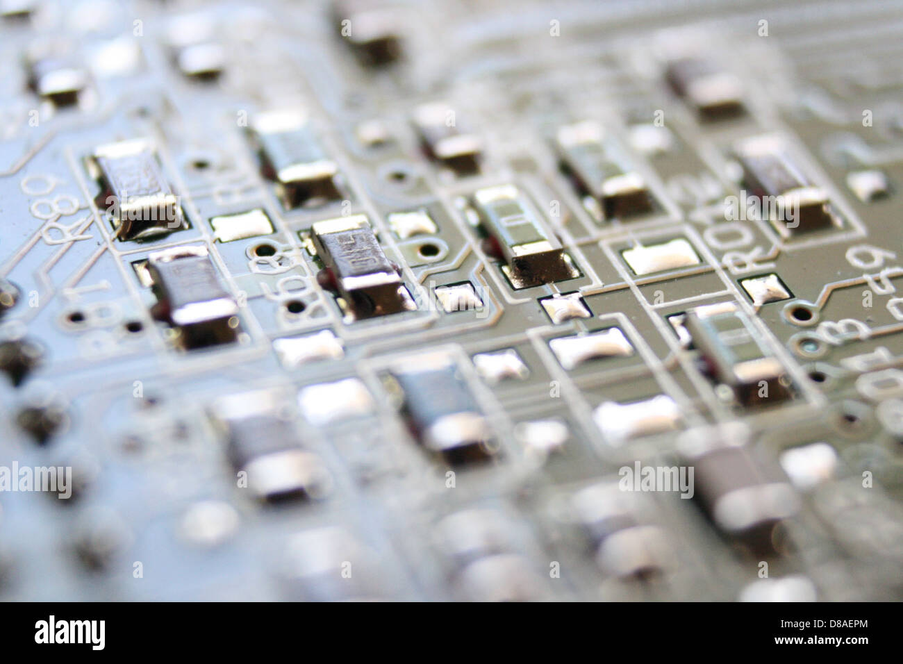 Vista ravvicinata di una scheda a circuito integrato, che mostra l'intricato design dei suoi percorsi, componenti e collegamenti. Questa tecnologia è essenziale nei moderni dispositivi elettronici. Foto Stock