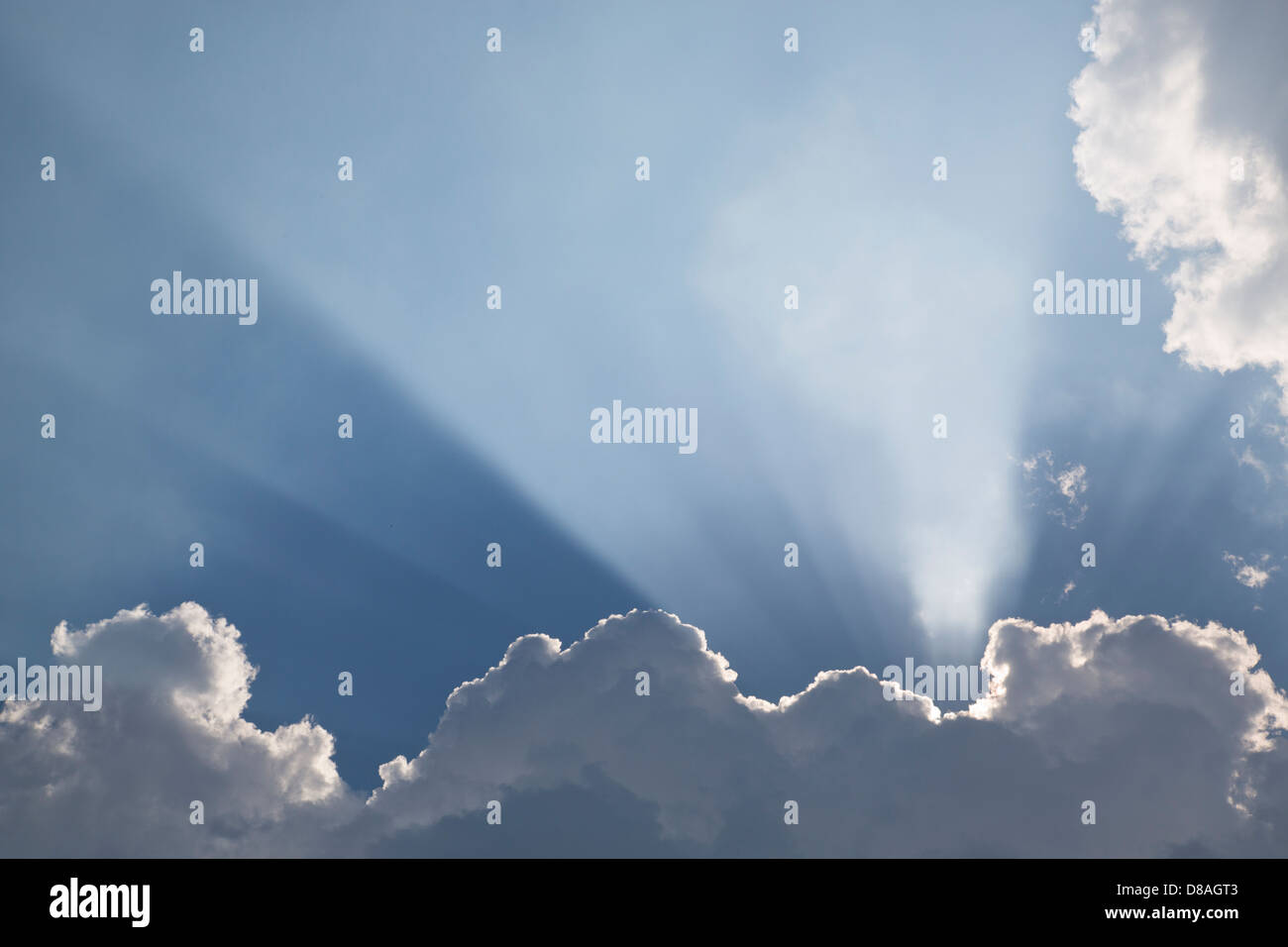 Raggi di sole lo streaming attraverso le nuvole Foto Stock