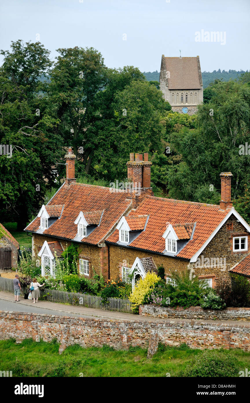 Red Brick cottages con finestre dormer e Giardini e Chiesa di San Lorenzo nel villaggio di Castle Rising, Norfolk, Inghilterra Foto Stock