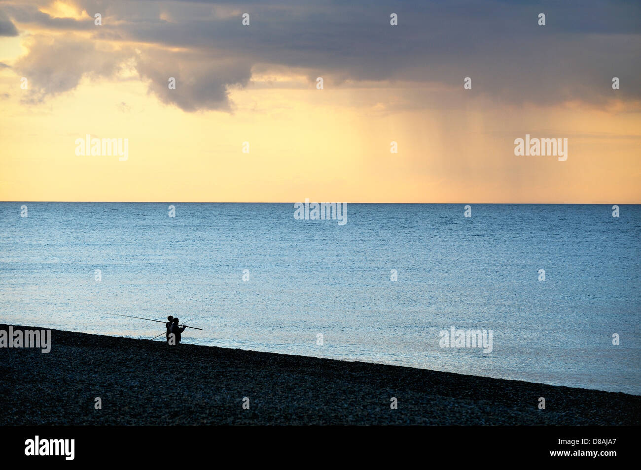 Due pescatori di mare i pescatori su Cley shingle Beach a nord di Norfolk Costa del patrimonio. Estate luce della sera Foto Stock