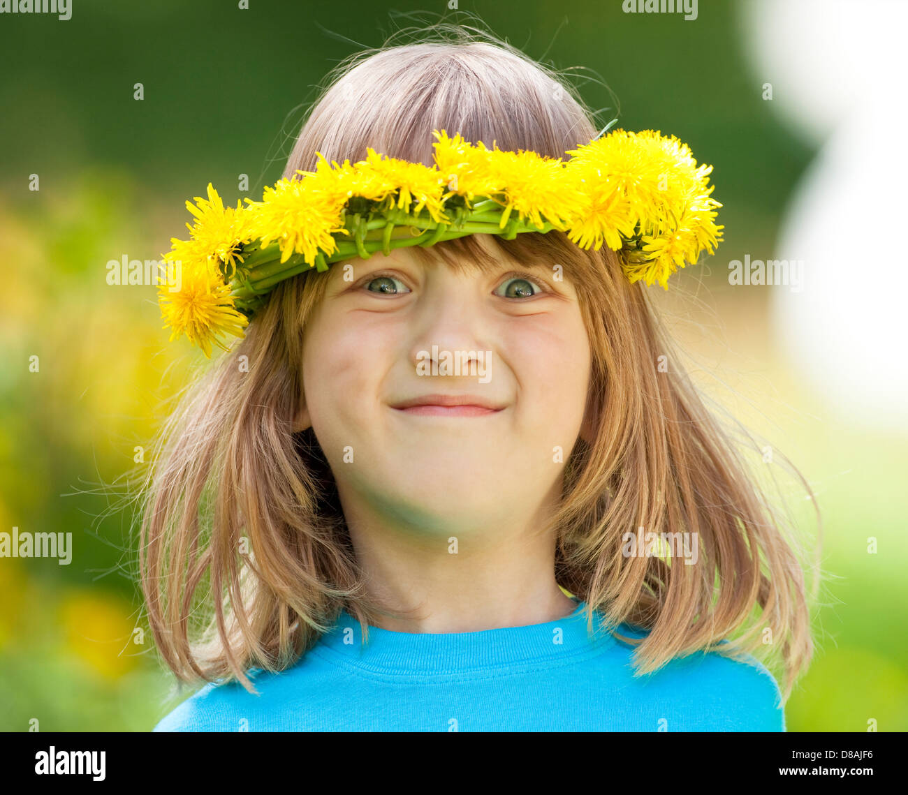 Ritratto di un ragazzo con lunghi capelli biondi e ghirlande di fiori Foto Stock