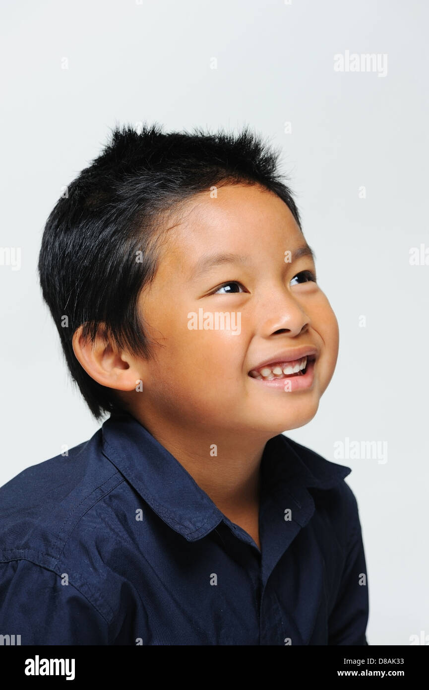 Ragazzo asiatico cercando e sorridente Foto Stock