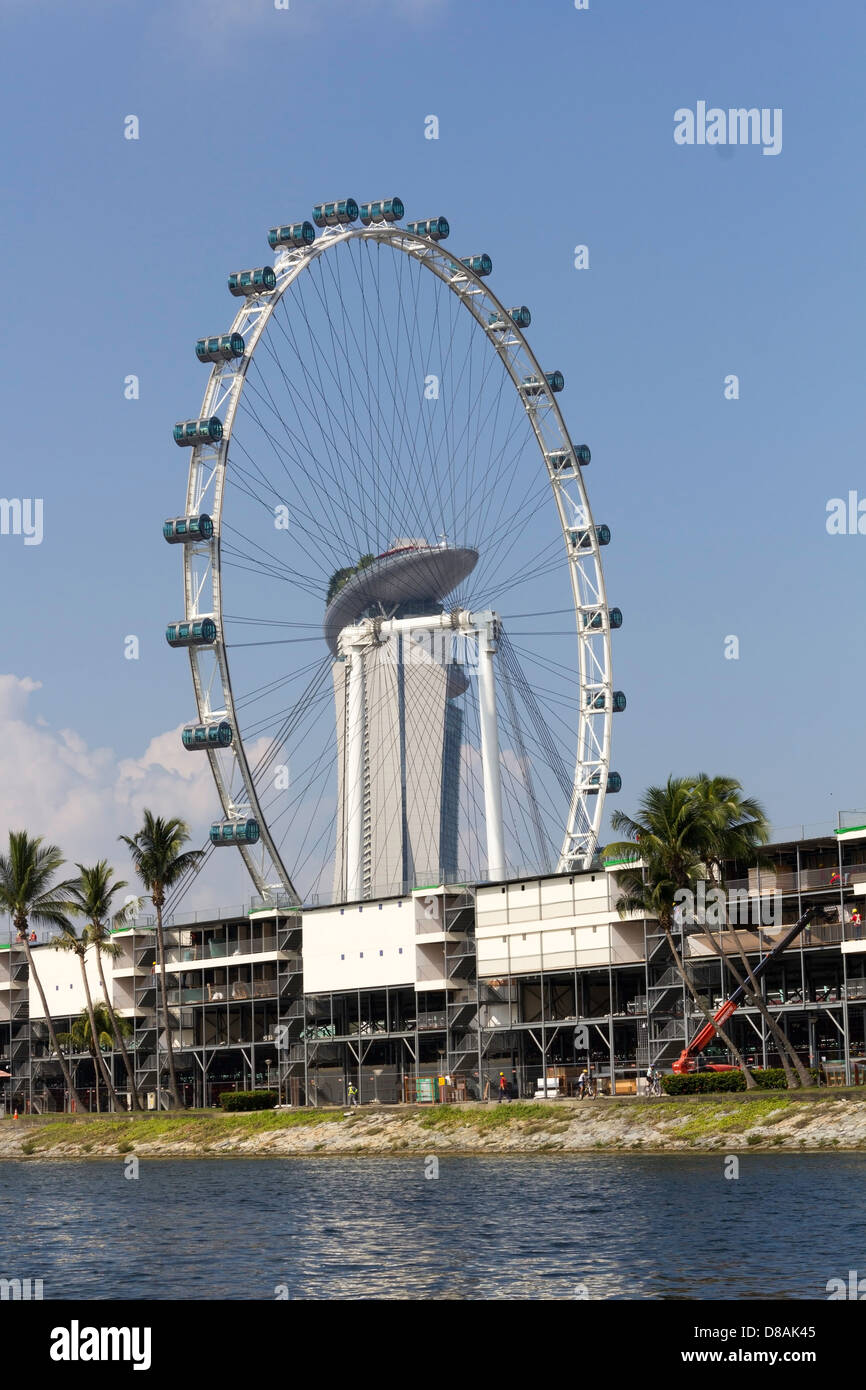 Il Singapore Flyer, il Marina Bay Sands e fabbricati temporanei sulla riva d'acqua. Costruzione per la Formula Uno in corso. Foto Stock