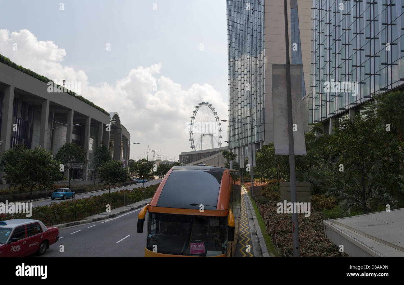 Autobus turistico per Sentosa di fronte a Marina Bay Sands in Singapore con Singapore Flyer in background, per il trasporto di passeggeri Foto Stock