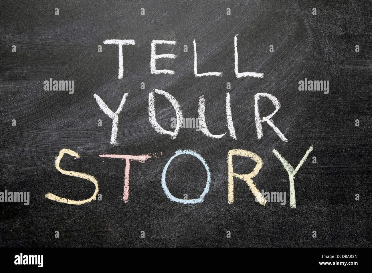 Raccontaci la tua storia una frase scritta a mano sulla scuola di Blackboard Foto Stock