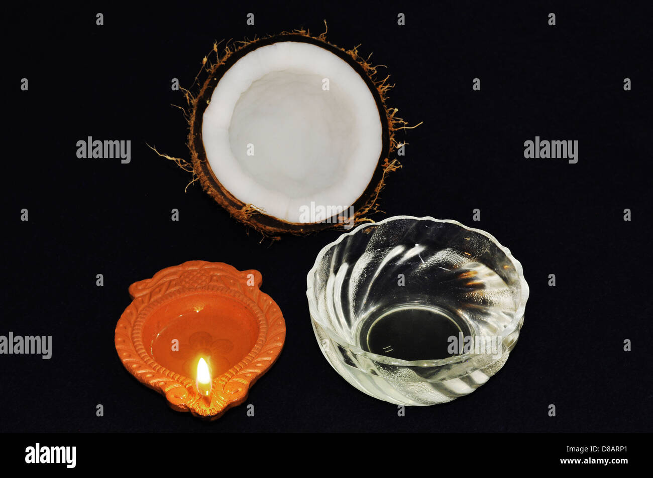 Noce di cocco, olio di noce di cocco e una lampada Foto Stock