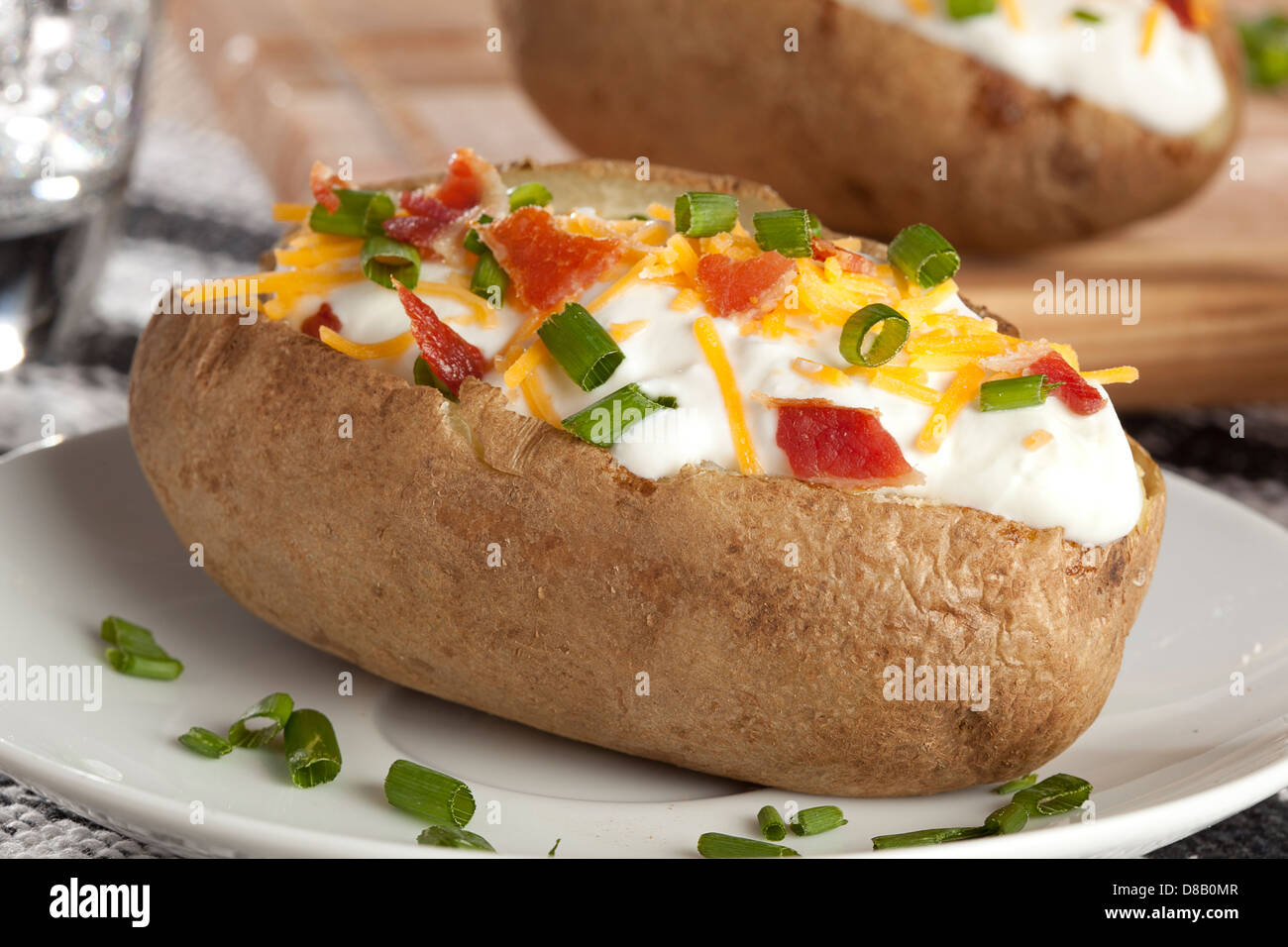 Hot di patate al forno con erba cipollina, formaggio e panna acida Foto Stock