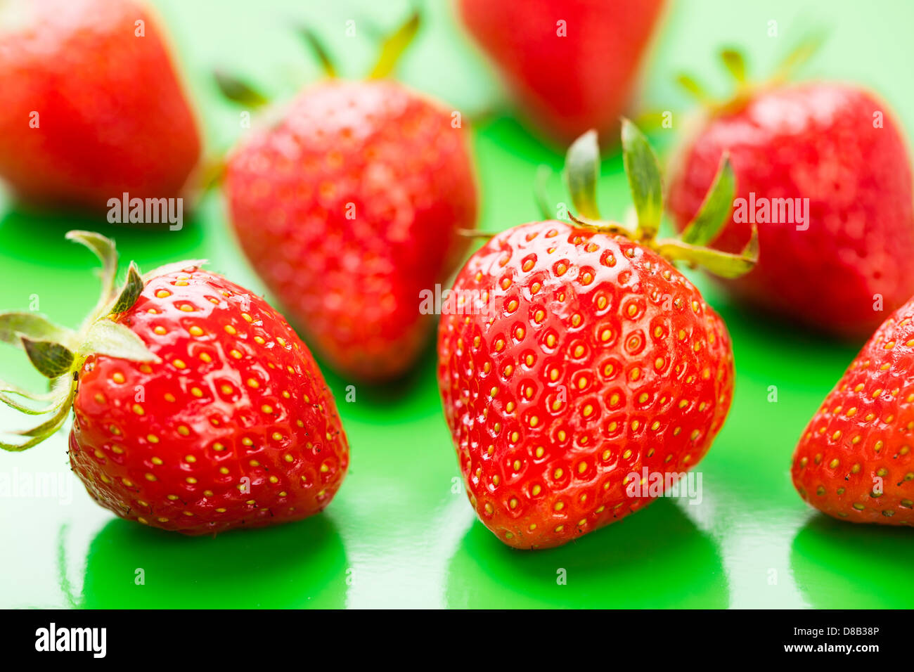 Gruppo di fragole su sfondo verde Foto Stock