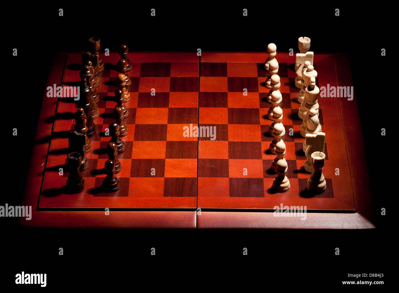 Classiche in legno scacchiera con pezzi di scacchi contro uno sfondo Foto Stock