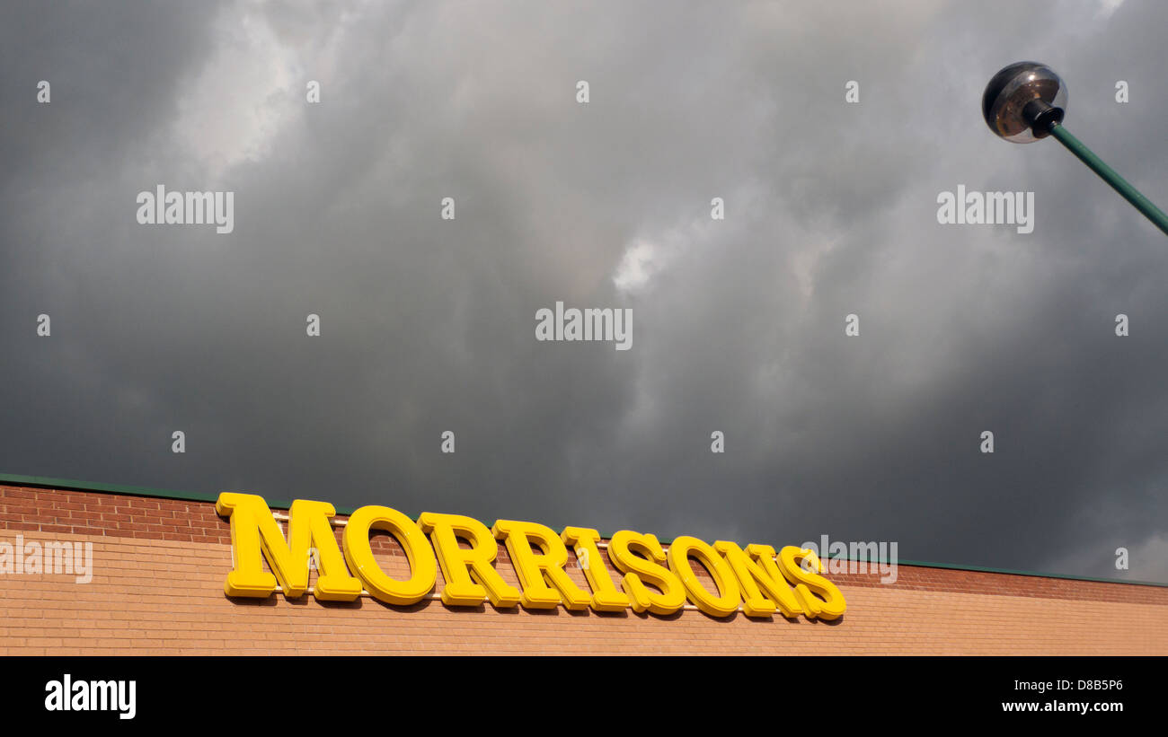 Morrisons supermercato segno illuminato contro una dark sky forboding Cardiff Wales UK Foto Stock