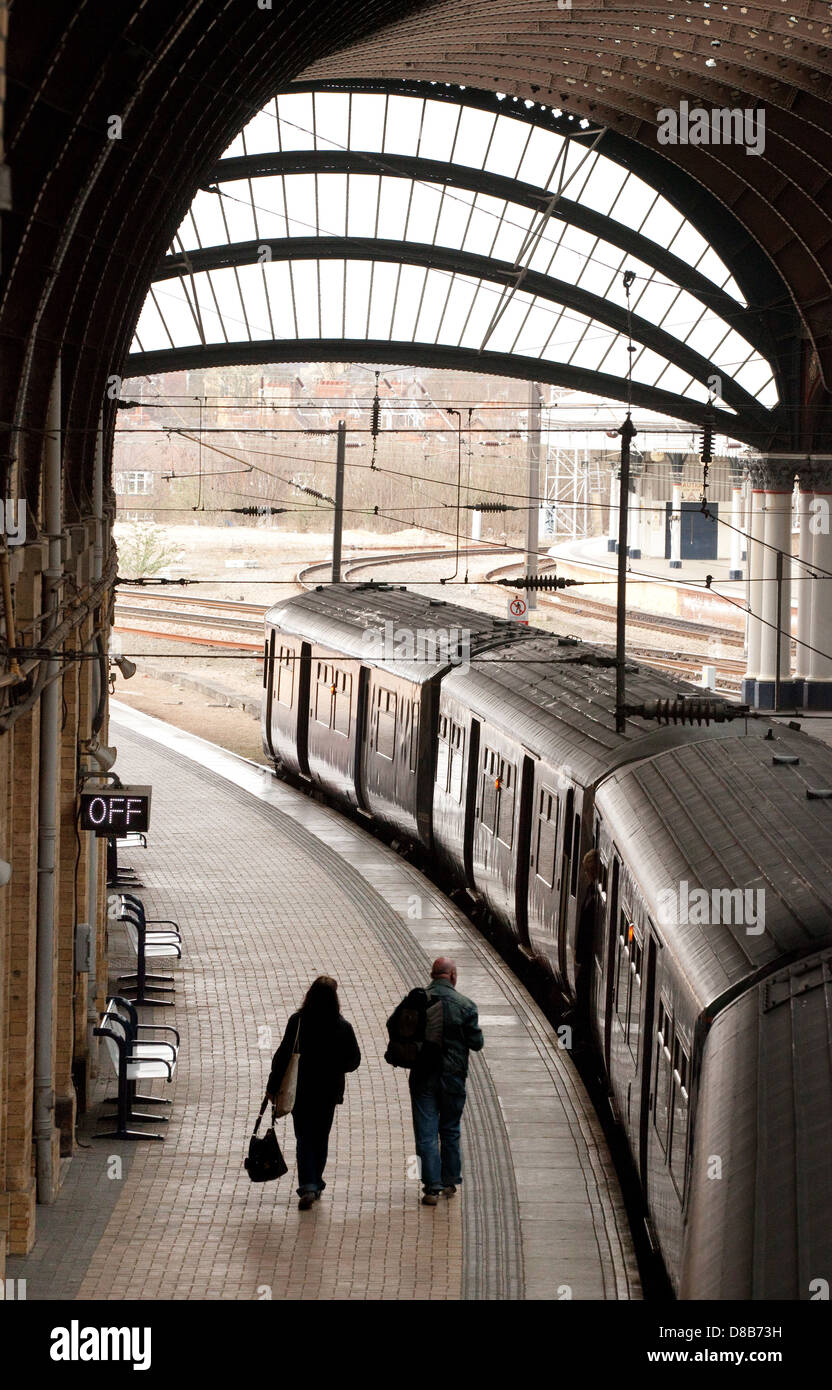 Un paio di persone a prendere un treno per la piattaforma, la stazione ferroviaria di York, Yorkshire Regno Unito Foto Stock