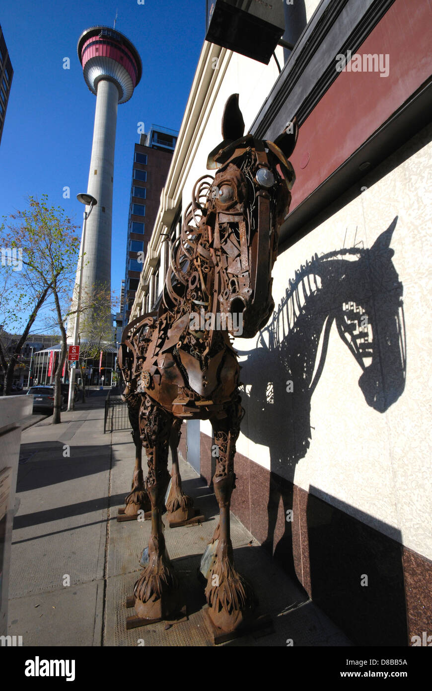 Una scultura a cavallo realizzata interamente con parti riciclate di macchinari agricoli saldate insieme e situata in un angolo di strada nel centro di Calgary, Alberta Foto Stock