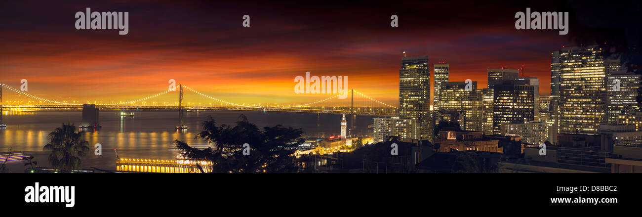 San Francisco California settentrionale dello skyline della città e di Oakland Bay Bridge a panorama al tramonto Foto Stock