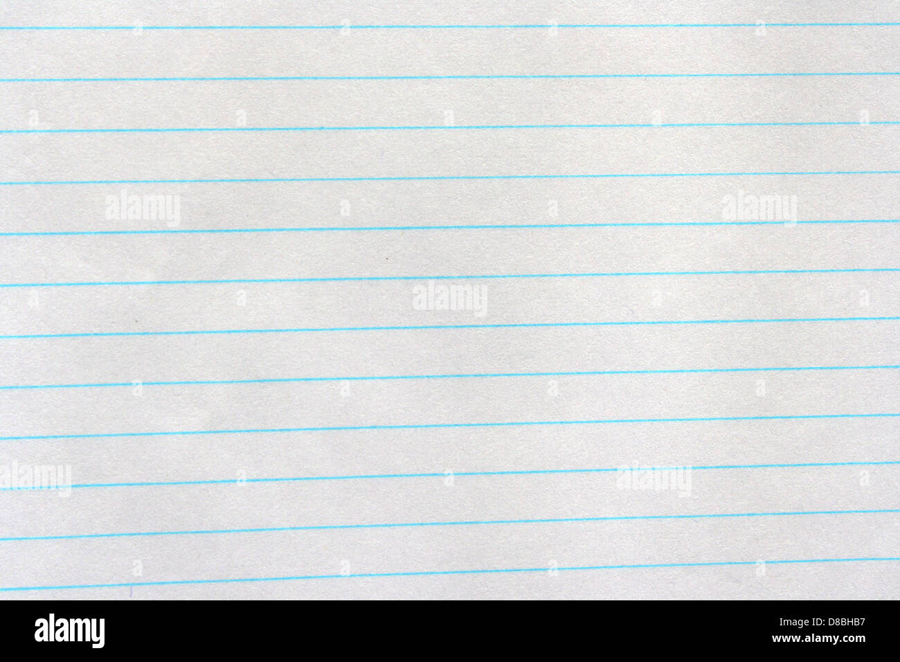 Un primo piano di carta per notebook che ne mostra la consistenza. Questo tipo di carta è comunemente usato per scrivere o disegnare, con linee visibili e la caratteristica sensazione della carta leggera. Foto Stock