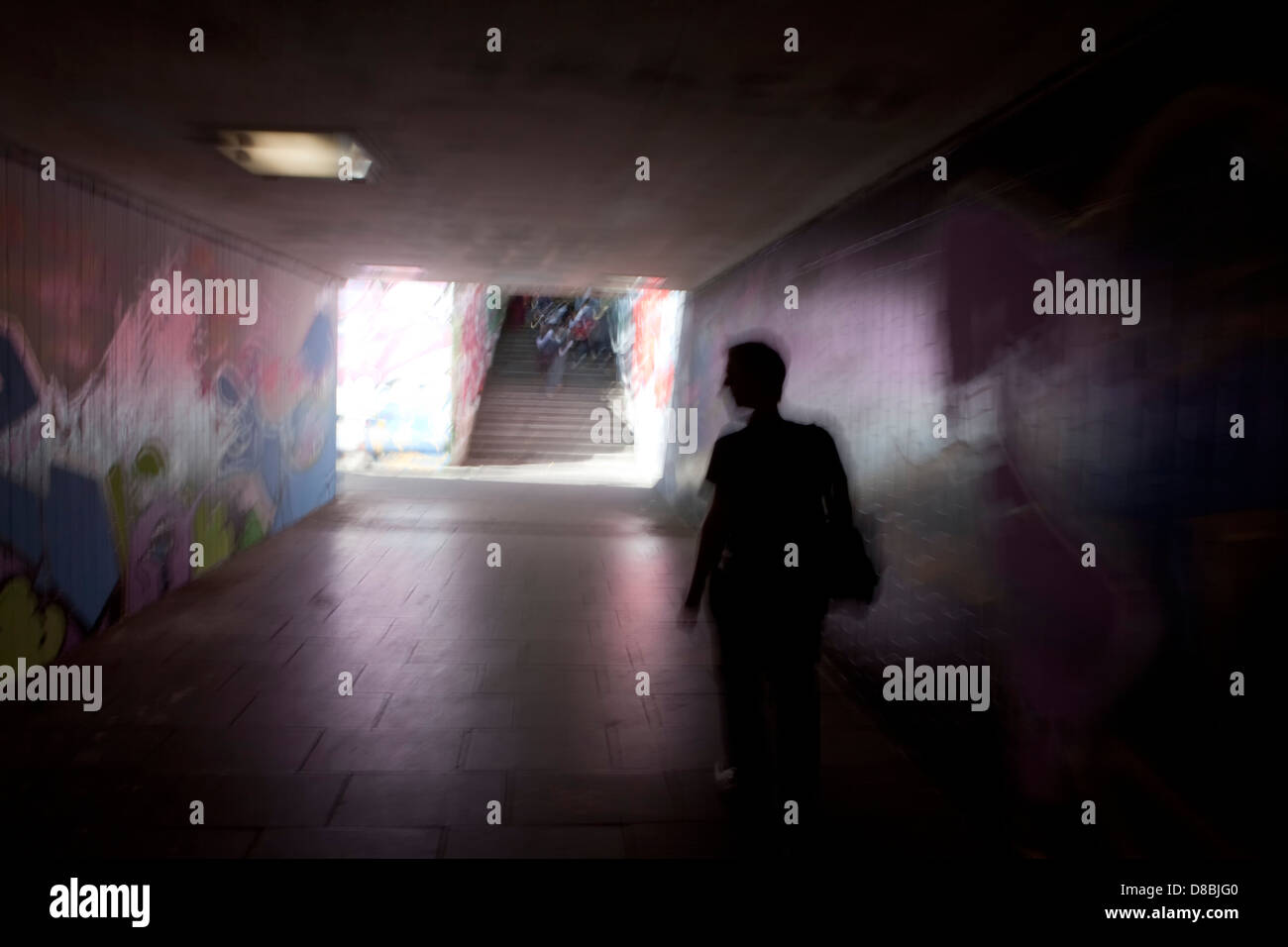 Un uomo che cammina in un tunnel scuro con graffiti, immagine simbolica di panico, Trier, Renania-Palatinato, Germania, Europa Foto Stock