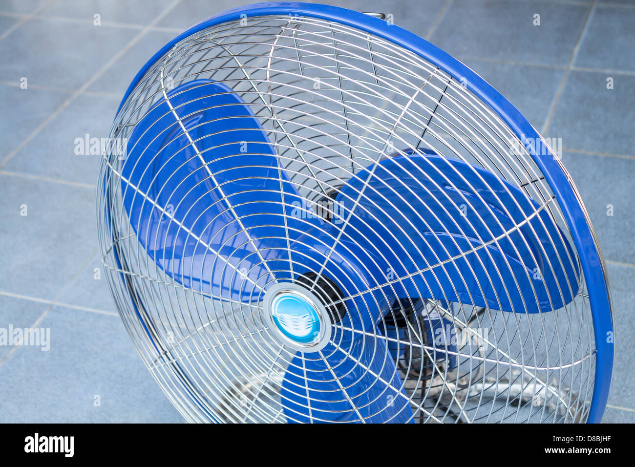 Parte anteriore del ventilatore industriale sul pavimento di colore blu Foto Stock