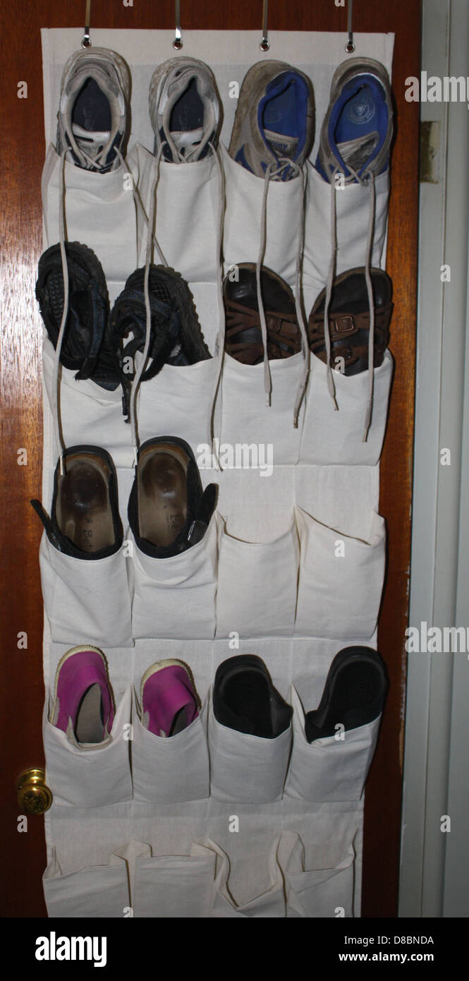 Questa immagine mostra le scarpe ordinate in un armadio su un portapacchi. Le scarpe sono disposte in base al tipo, con vari stili e colori visibili, offrendo una visione chiara della collezione di calzature. Foto Stock