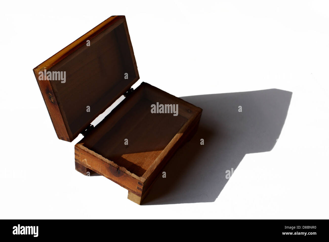 Una piccola scatola di legno con coperchio incernierato, che offre una soluzione di stoccaggio affascinante. Realizzata in legno naturale, questa scatola può essere utilizzata per riporre piccoli oggetti come gioielli, souvenir o bigiotteria. Il suo design classico e le dimensioni compatte lo rendono pratico e decorativo, adatto per l'organizzazione domestica o come regalo premuroso. Foto Stock