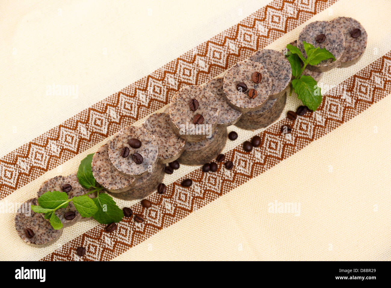 Disposizione dei fatti a mano sapone aromatizzato bar con i chicchi di caffè verde e foglie di lavanda. Foto Stock