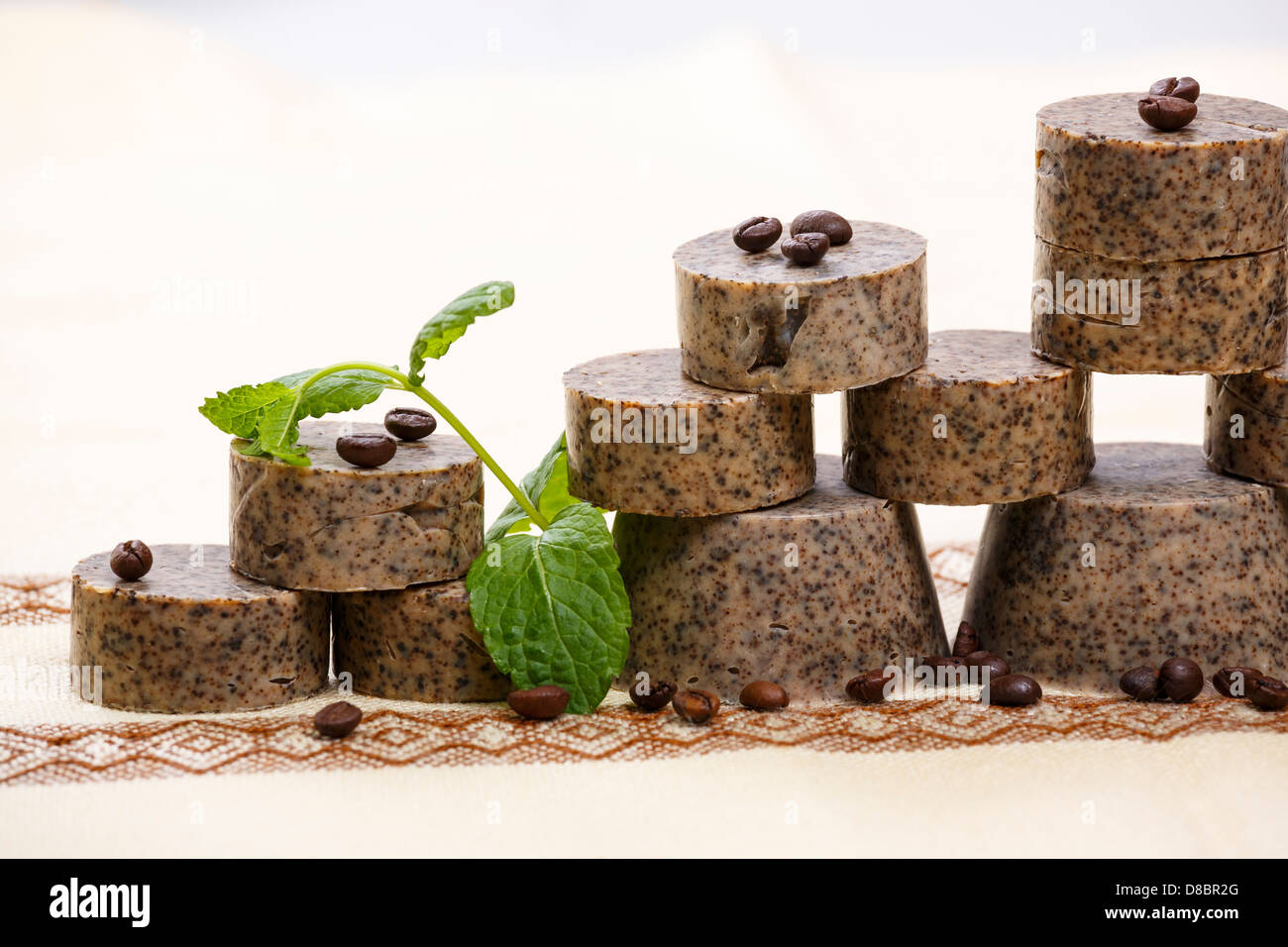 Pila artigianale di saponette con i chicchi di caffè verde e foglie di lavanda. Foto Stock