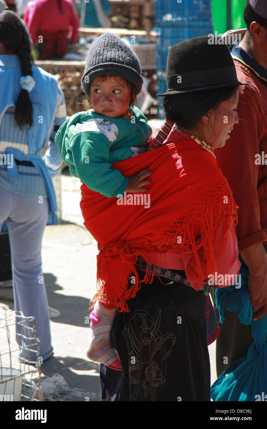 Il quechua donna che porta il suo bambino sulla schiena. Ecuador Foto Stock