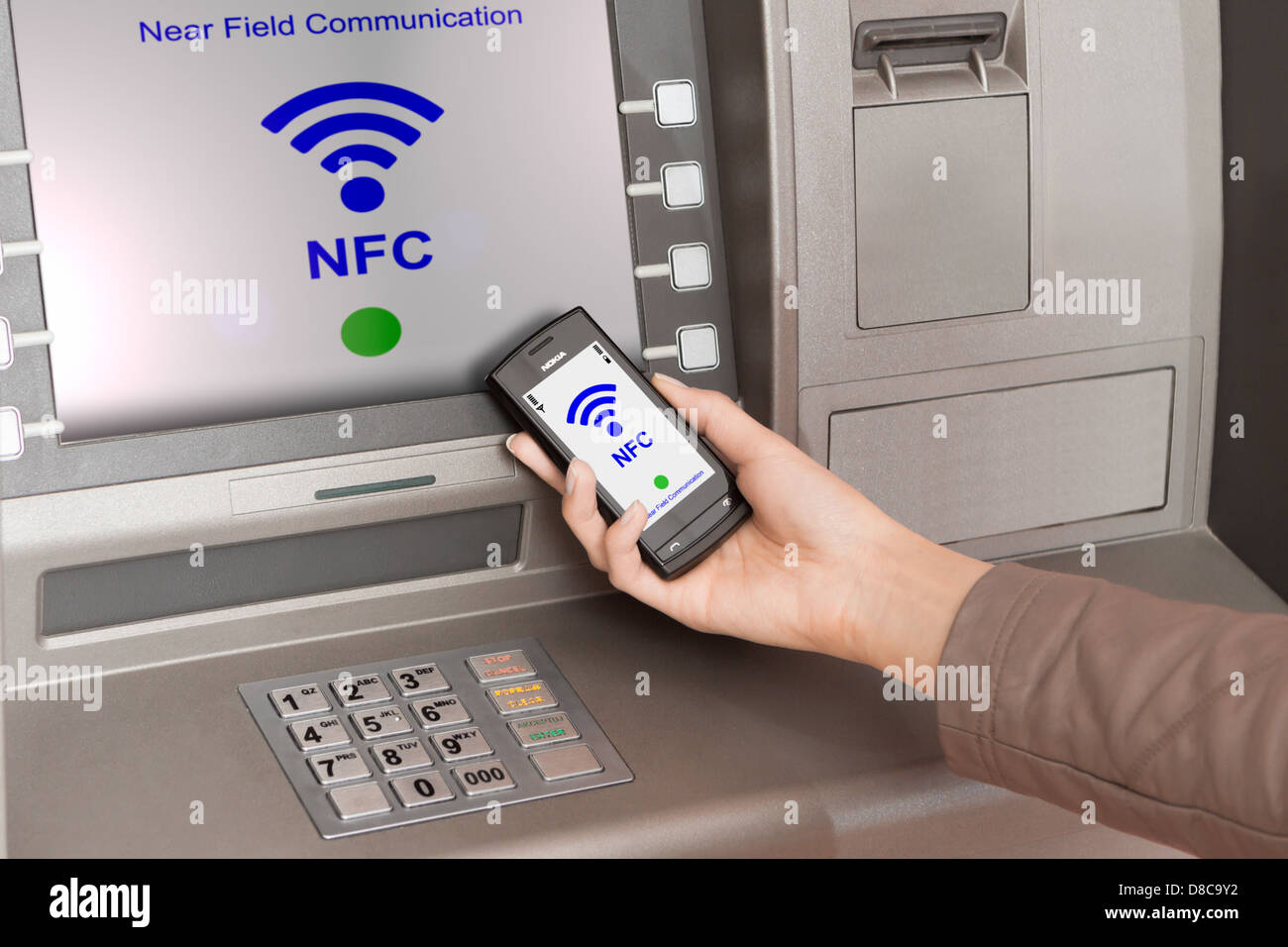Prelevare denaro dal bancomat con un telefono cellulare un terminale NFC Foto Stock