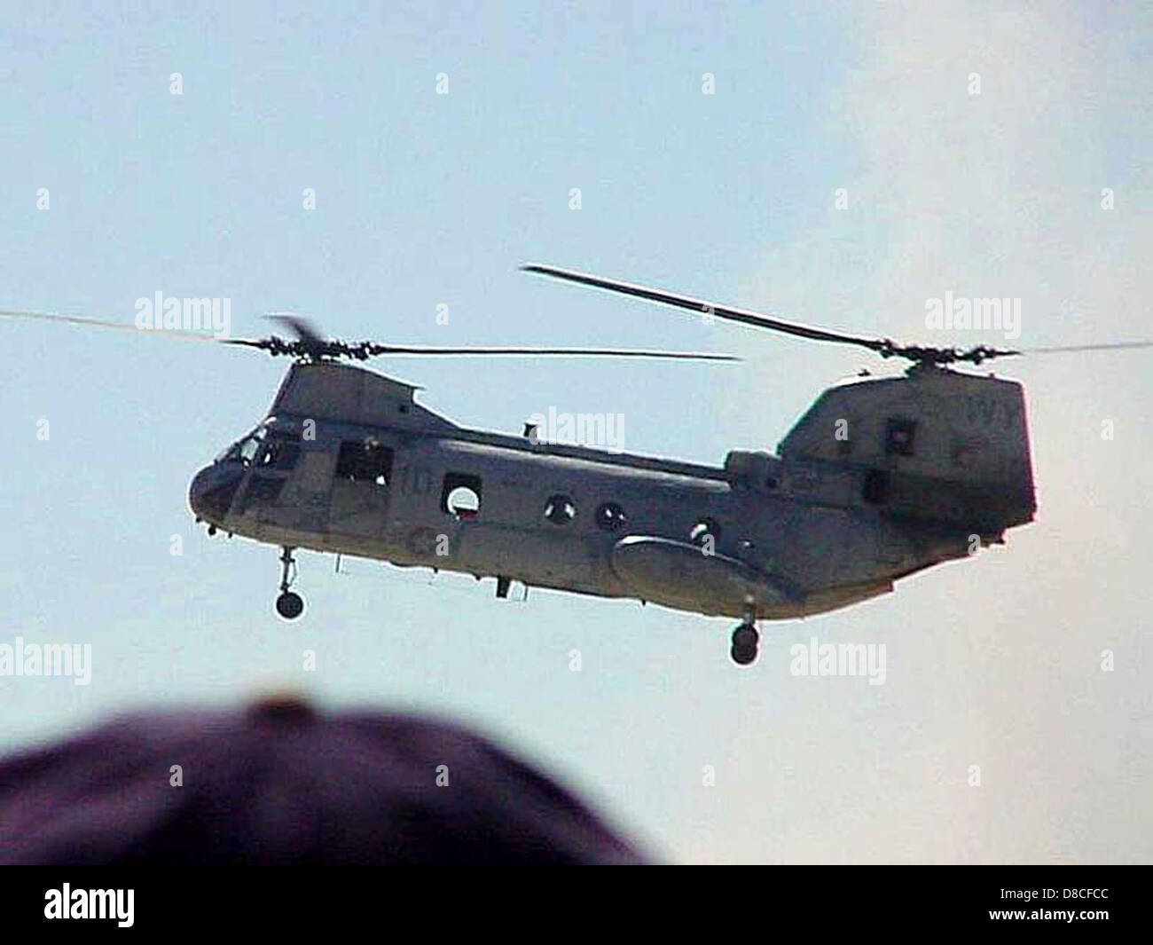 Una foto di scorta di un grande elicottero che vola nel cielo. L'elicottero è mostrato in volo, con le sue pale rotanti che ruotano sopra il paesaggio, tipicamente utilizzato per il trasporto o i servizi di emergenza. Foto Stock