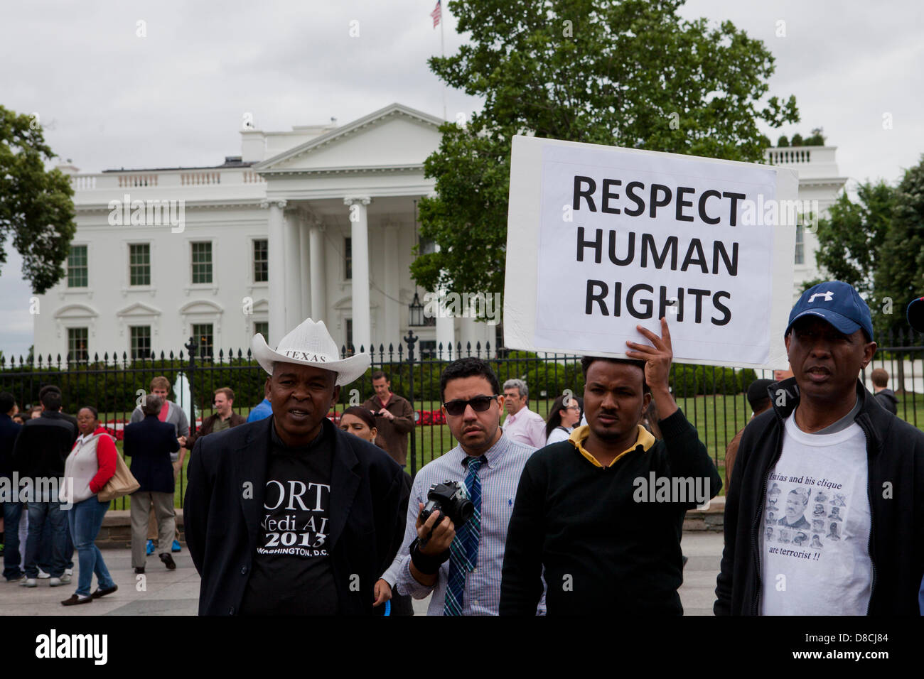 Attivista per i diritti umani tenendo un cartello fuori della Casa Bianca palizzata - Washington DC, Stati Uniti d'America Foto Stock