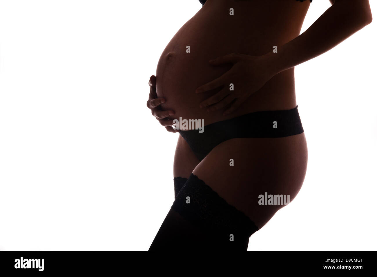 Donna incinta azienda ventre con bracci 9 mese Foto Stock