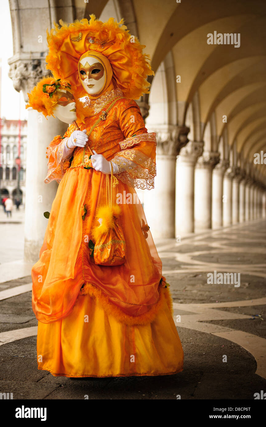 Una donna che indossa un costume arancione e maschera durante il Carnevale  di Venezia, Italia Foto stock - Alamy