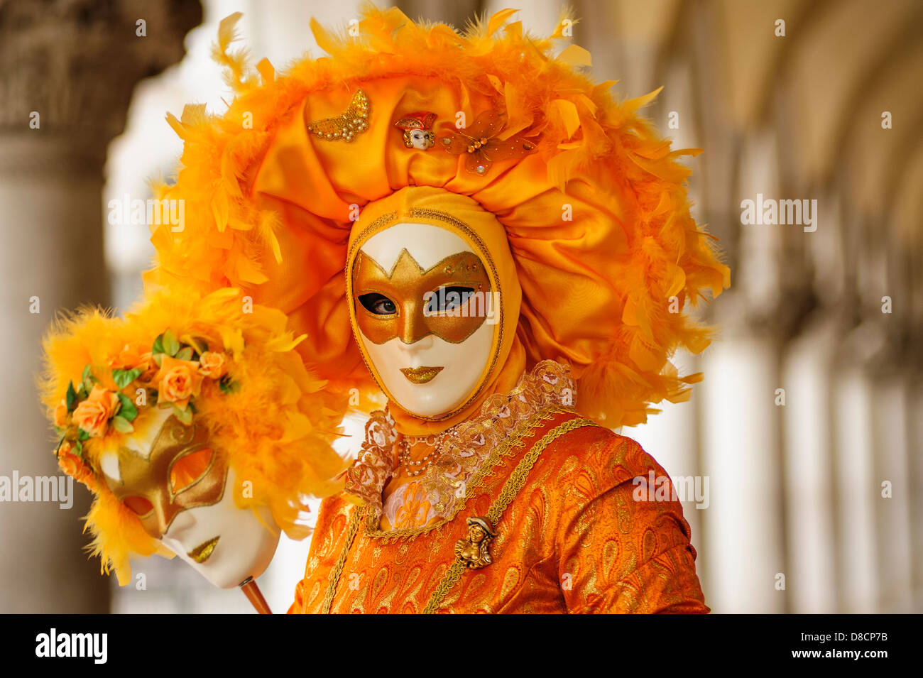 Una donna che indossa un costume arancione e maschera durante il Carnevale  di Venezia, Italia Foto stock - Alamy