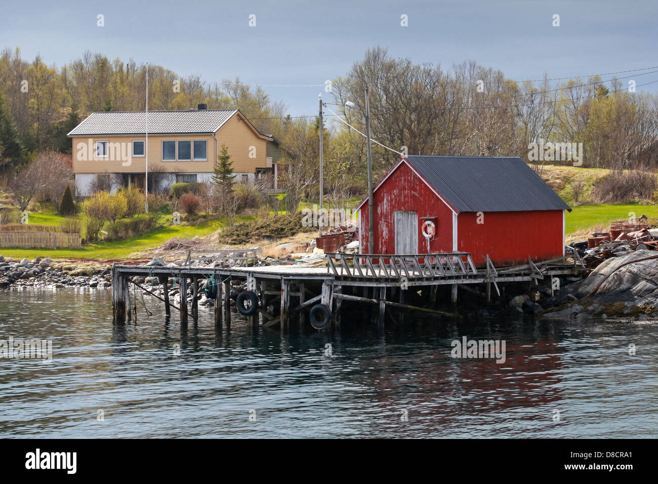 Tradizionale norvegese in legno rosso barca da pesca granaio sulla costa del mare in primavera Foto Stock