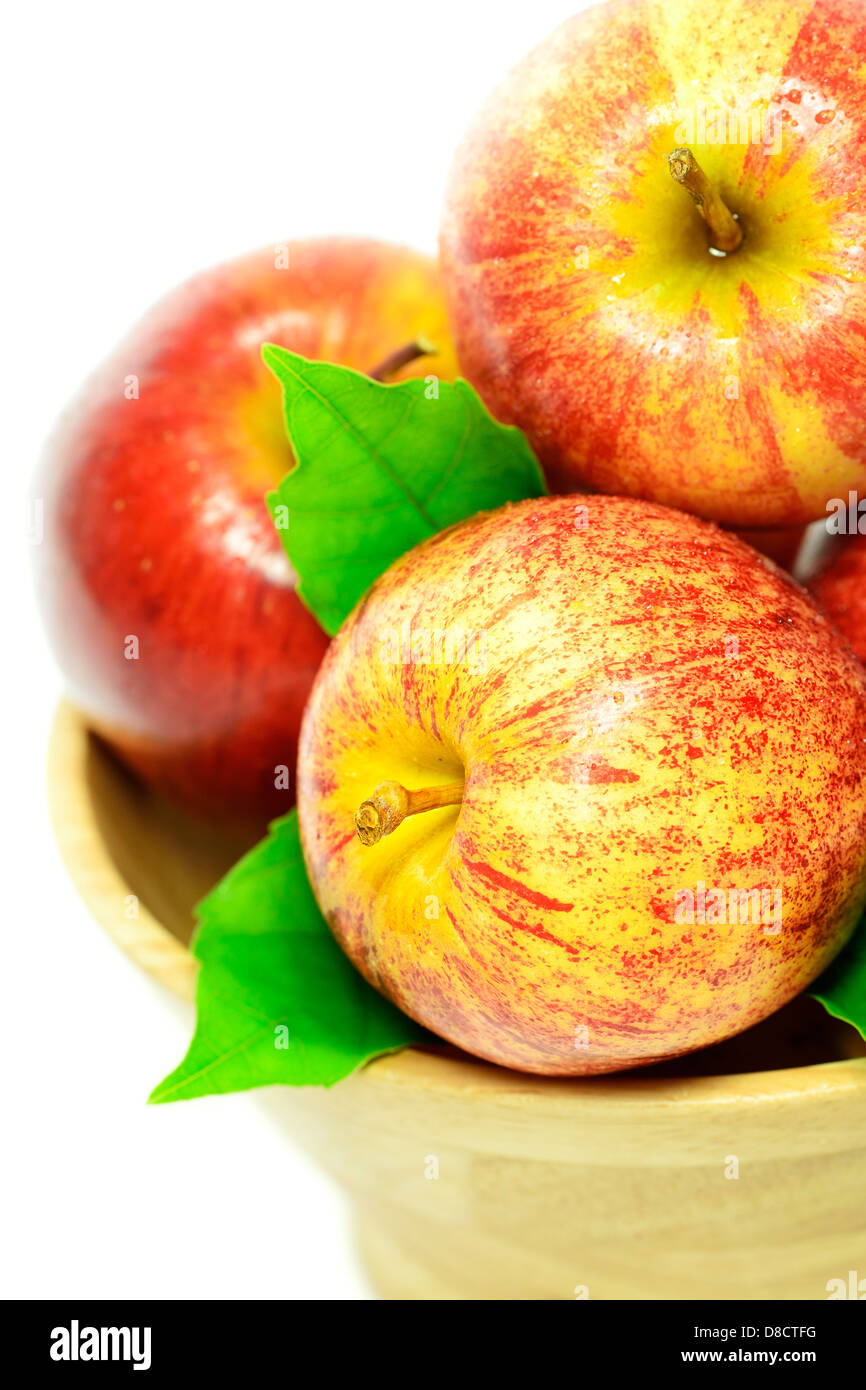 Le mele rosse in un cesto contro uno sfondo bianco Foto Stock