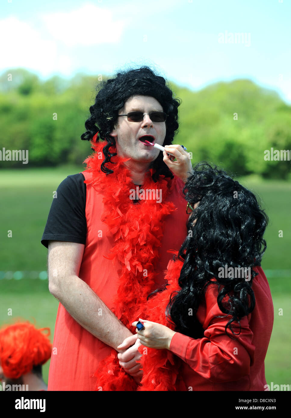 Un uomo ha il rossetto rosso applicato come egli prende parte con centinaia di persone e anche alcuni cani tutti abbigliati come Kate Bush cantare e ballare di Wuthering Heights che tentano di rompere un unofficial record del mondo per la medicazione di persone come il famoso cantante in un luogo . La manifestazione organizzata da Shambush! Si è tenuto nel parco Stanmer Brighton e oggi è parte della Brighton Fringe Festival . Foto Stock