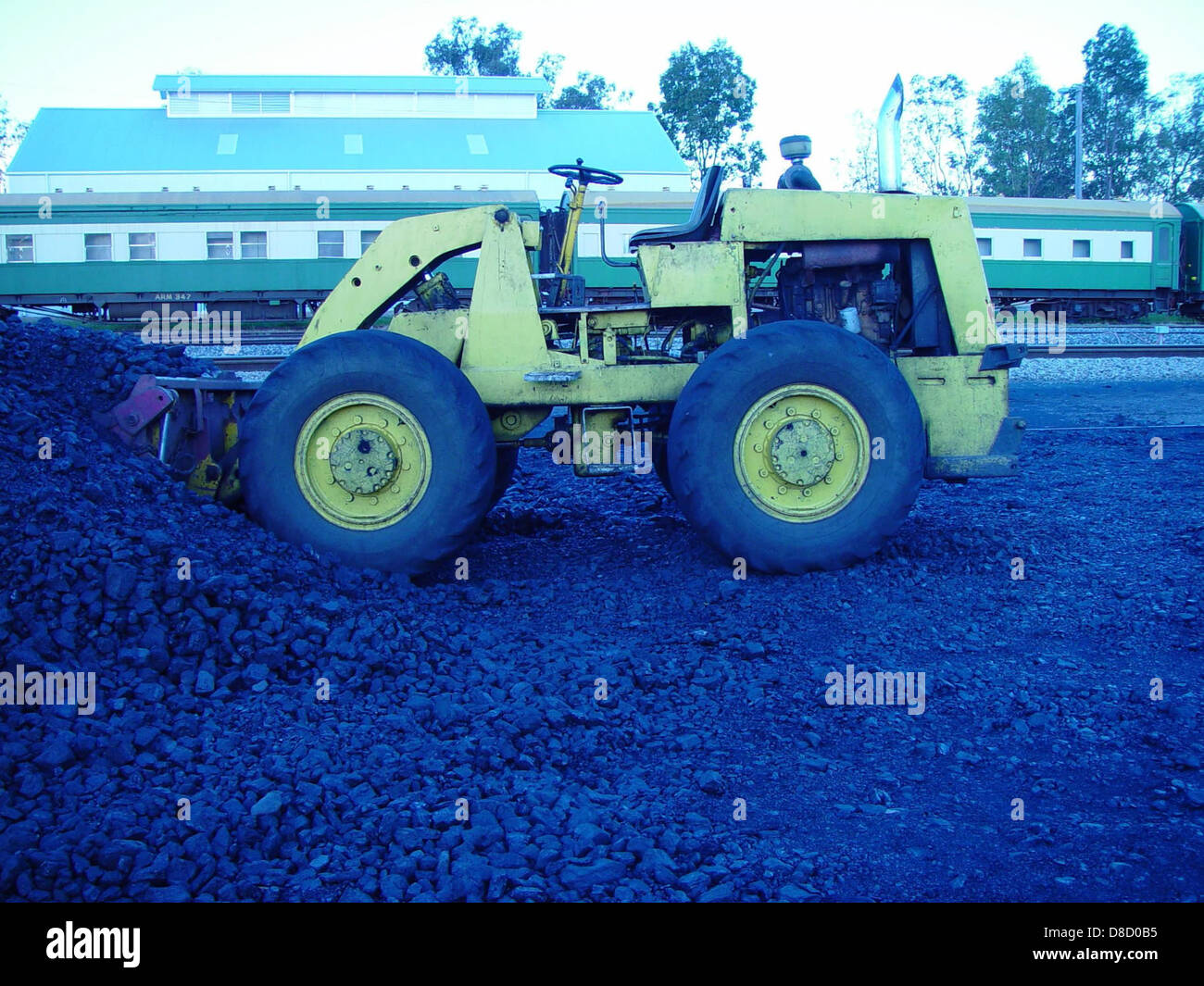 Un caricatore frontale è collegato a un veicolo a carbone, utilizzato per il trasporto di carbone. Questi macchinari per impieghi gravosi sono fondamentali per l'industria mineraria e delle costruzioni, poiché aiutano a spostare grandi quantità di carbone per la lavorazione e la distribuzione. Foto Stock